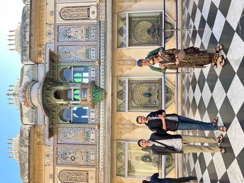 Family posing in front of a historic structure with intricate designs.