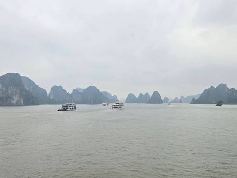       Boats sailing in a bay with unique rock formations.
  