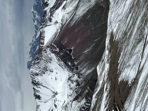 Snow-covered mountains under a cloudy sky.