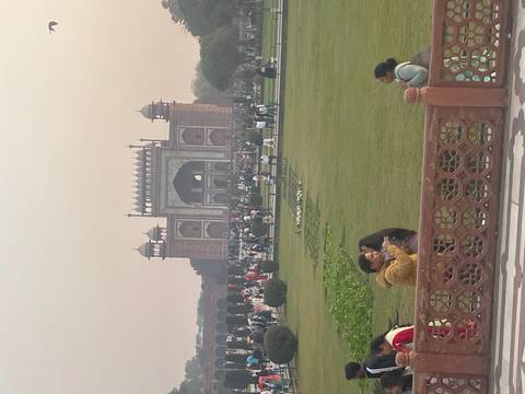 A garden with many people near an entrance gate.