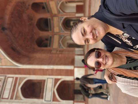 Two women posing in front of an architectural structure.