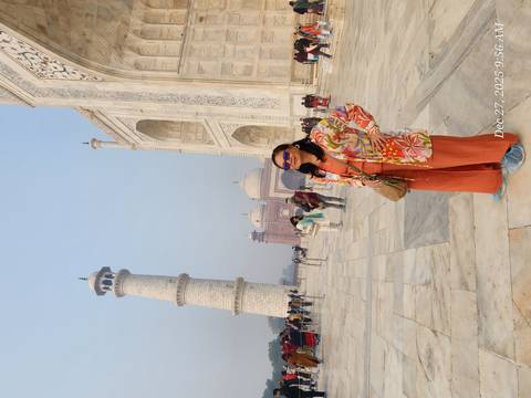       Woman posing in front of the Taj Mahal.
  