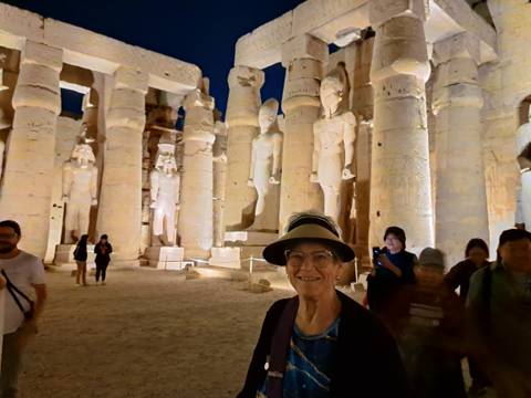 Man standing in illuminated ancient Egyptian temple at night.
