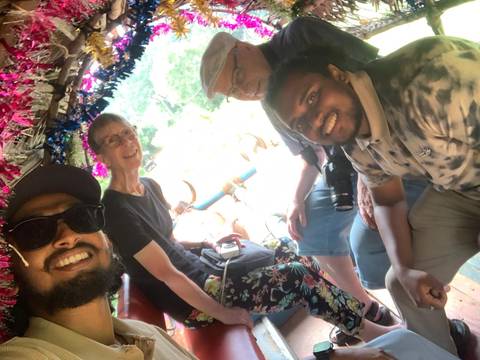 Group of people taking a selfie on a tuktuk ride.