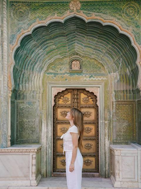 Woman standing in front of an ornate archway.