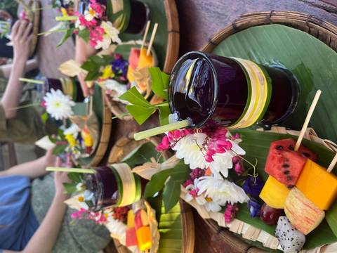       Juice and fruit platters with flowers on a table.
  