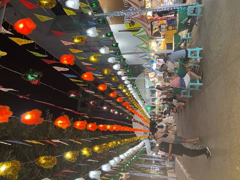       Night market with lights and people dining.
  