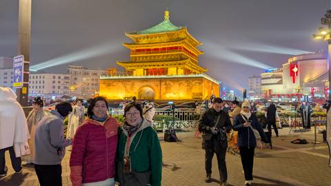 People in front of lit building at night.