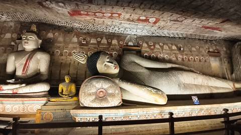 Statues inside a decorated cave.