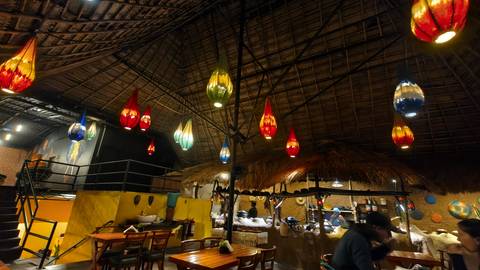 Interior of a restaurant with colorful hanging lights.