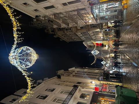 Streets decorated with chandeliers and lights at night.