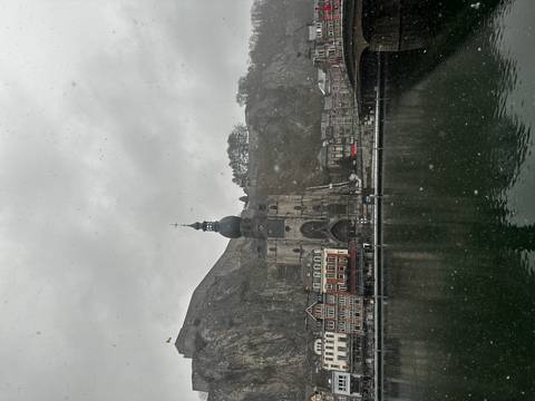 Historic building by the river on a cloudy day.