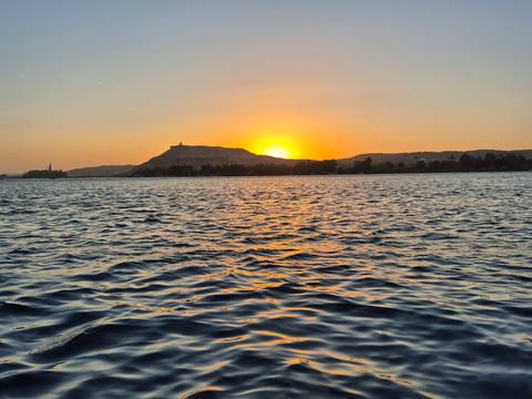 Sunset over the Nile River with rippling water.