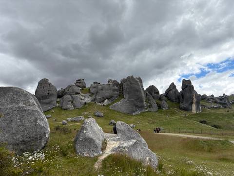       Large rock formations with visitors walking around.
  