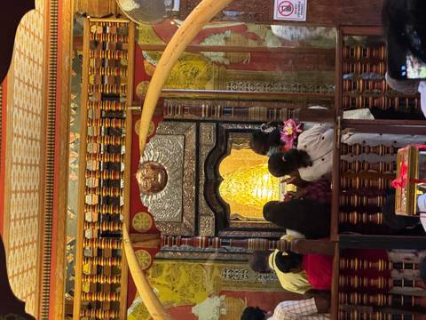 People observing a religious artifact inside a shrine.