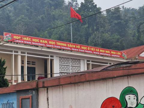 A building with a long banner containing educational text.