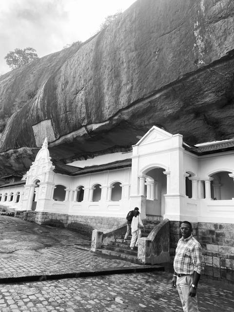       Monastery built into a natural rock overhang.
  