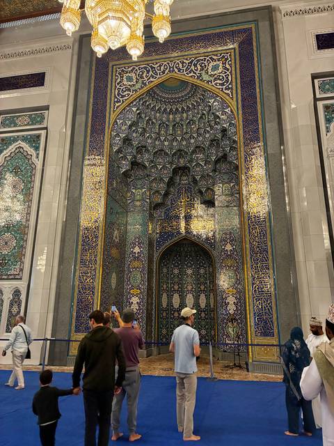       Close-up of intricate tile work and Arabic calligraphy in a mosque.
  