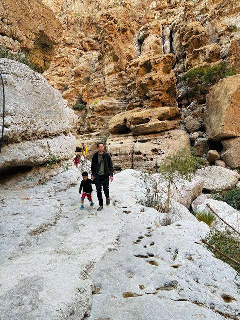       Family hiking through rocky landscape.
  