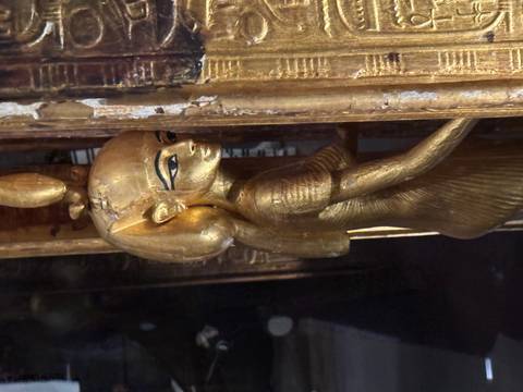       Close-up view of an ancient Egyptian statue indoors.
  