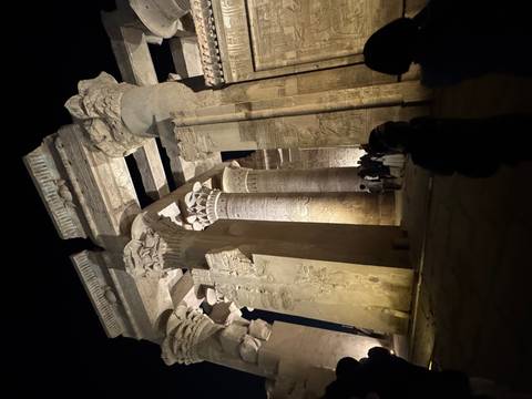       Ancient Egyptian columns with hieroglyphs lit up at night.
  