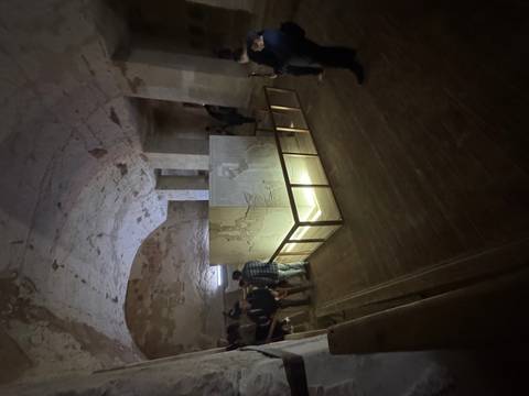 Dimly lit ancient Egyptian tomb with hieroglyphs.