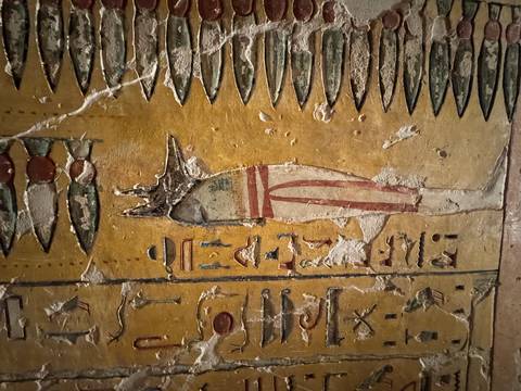       Close-up of an Egyptian wall painting with detailed art.
  