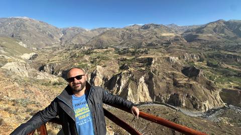       Man posing with a view of the canyon in the background.
  