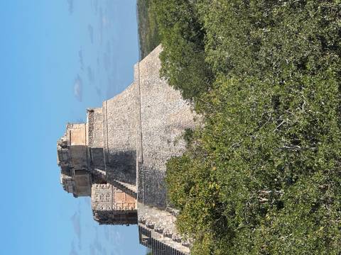 A large stone pyramid with trees in the foreground.