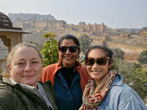 Three women with a historic fort in the background.