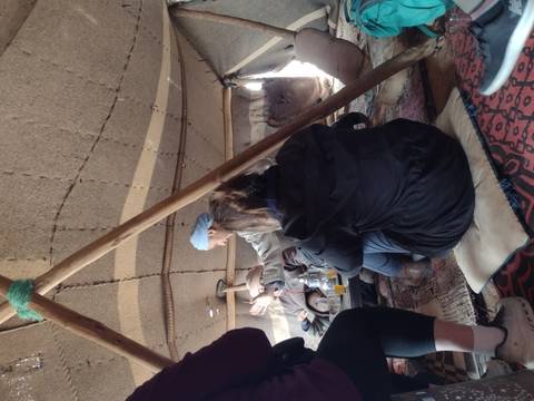       Interior of a tent with people sitting.
  