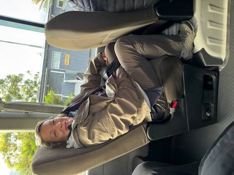 Woman sitting comfortably on a bus.