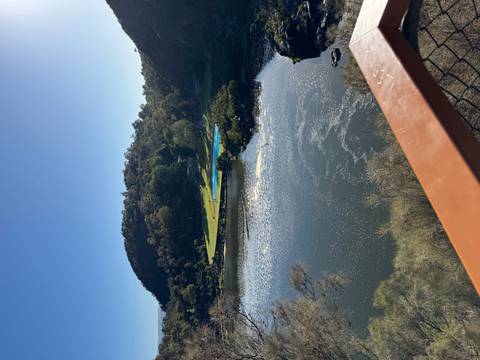 View of a river and green hills from a bridge.