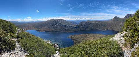 Panoramic view of a large lake surrounded by mountains.