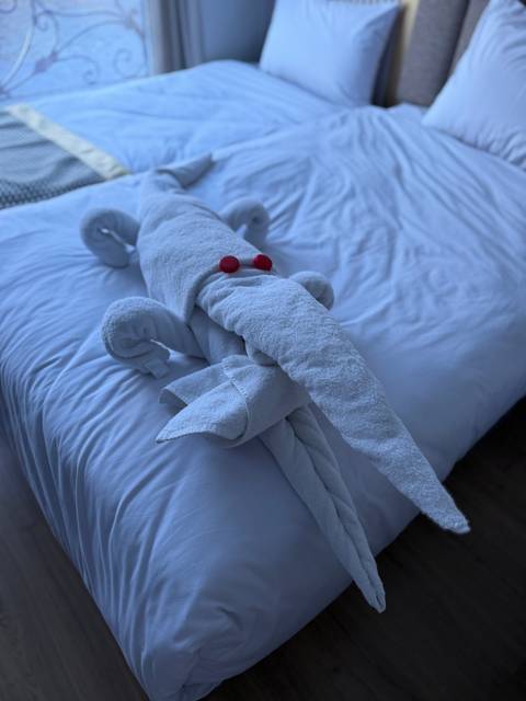 Close-up of towel art shaped as an animal on a bed.