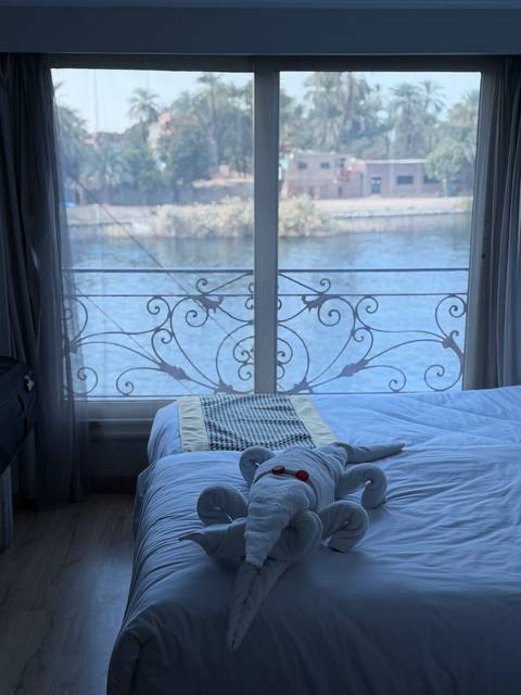 Towel art on a bed with river view.