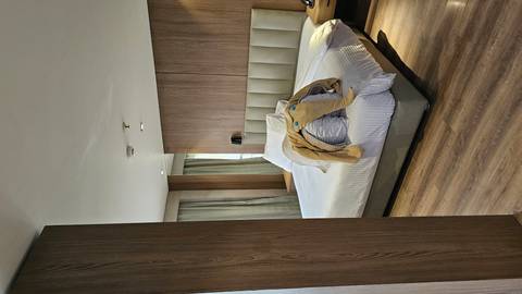 Modern hotel room with a double bed and wooden decor.