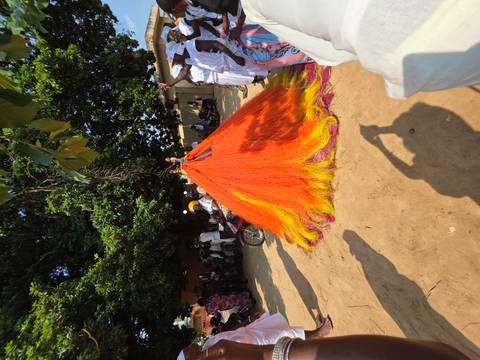       Colorful ceremonial structure with crowds gathered around.
  