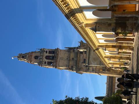 A tall bell tower part of a historic complex in Cordoba.