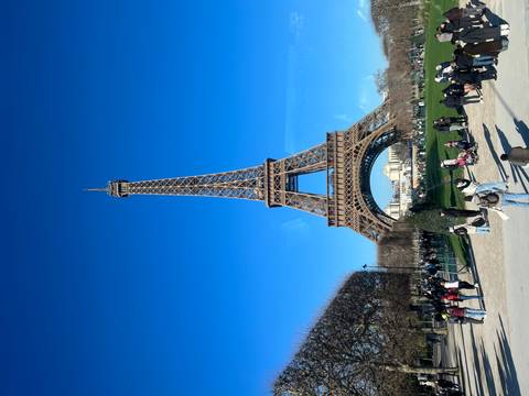Eiffel Tower with people walking around.