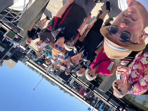 Group photo with multiple people posing outdoors.