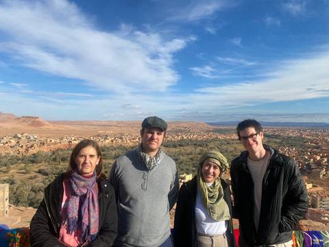       Group of people posing with a rocky desert landscape in the background.
  