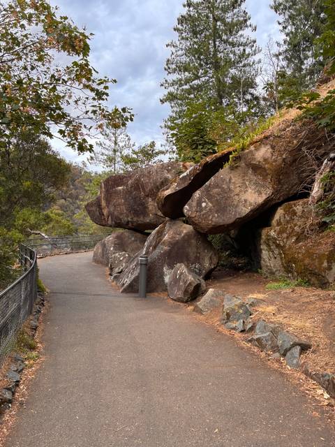 Rocky overhang along a walking path in nature.