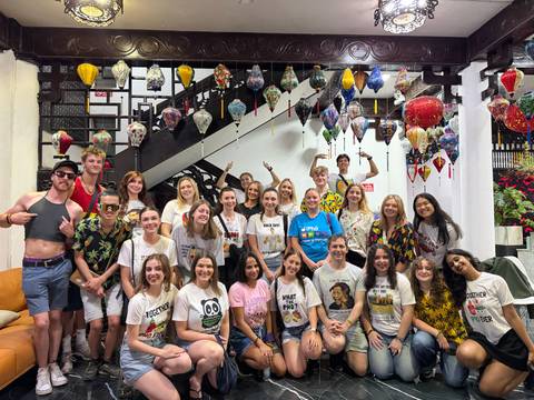 A group of people posing in a venue decorated with lanterns.