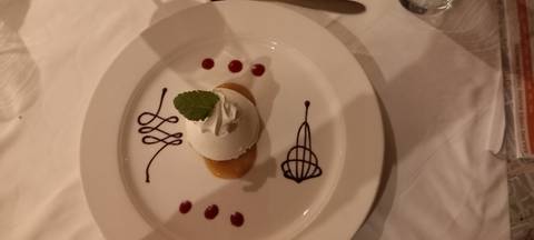 Dessert decorated with chocolate art on a plate.