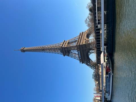 Eiffel Tower with clear sky above the river with boats.