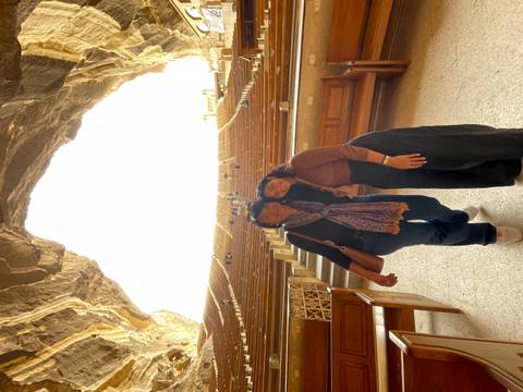 Two women posing in a large amphitheater.