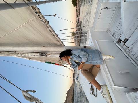 Woman sitting on a sailboat with scenic views.