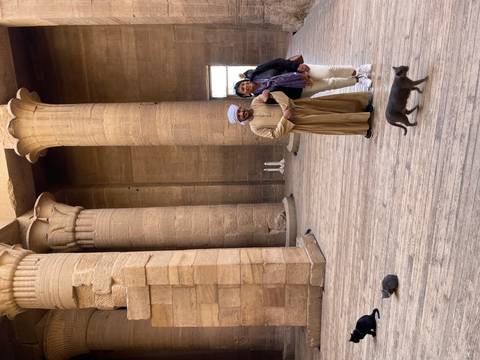 Two people posing in front of large ancient columns.