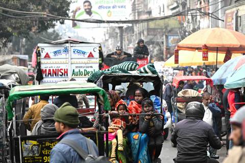 Busy street scene filled with rickshaws and people.